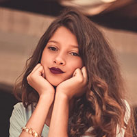 A woman with long hair and lipstick on her lips.